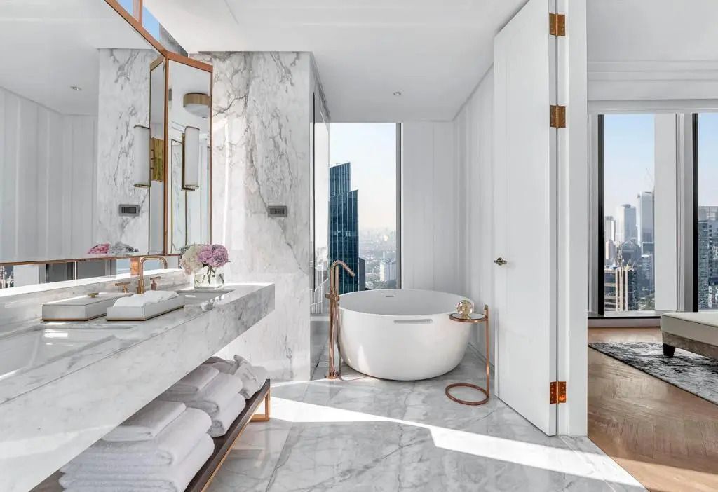 Luxuriöses Badezimmer mit freistehender Badewanne und Blick auf die Stadt