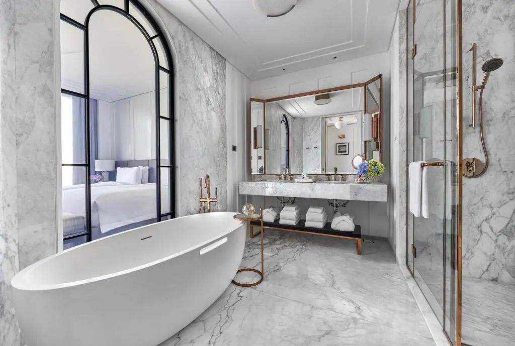 Luxuriöses Badezimmer mit freistehender Badewanne und Marmorwänden