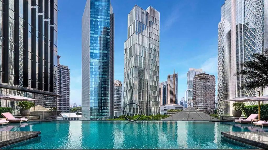 Moderne Gebäudefassade mit Glasfronten, reflektiert im Pool
