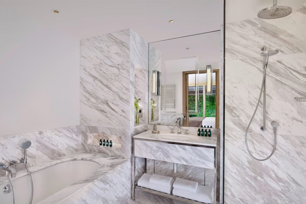 Luxuriöses Badezimmer mit Marmorwänden und großer Badewanne