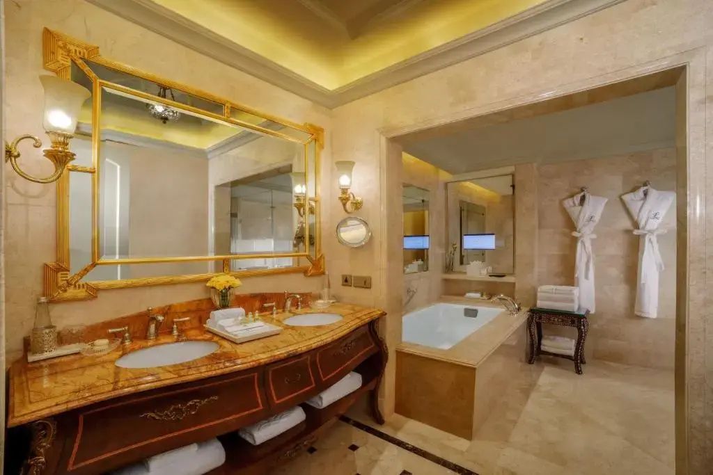 Geräumiges Badezimmer der Suite mit Doppelwaschbecken und Badewanne.