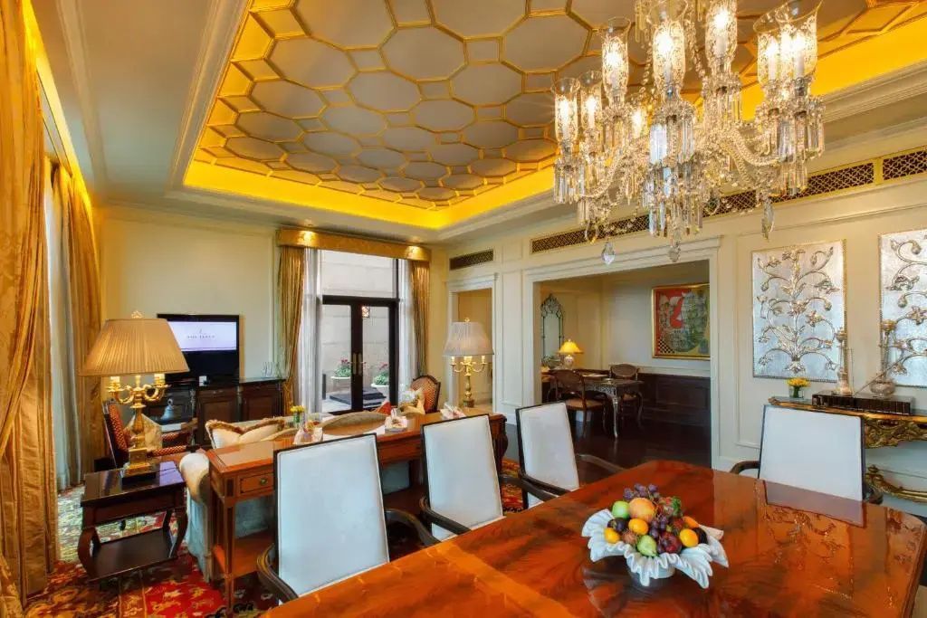 Essbereich in der Suite mit luxuriöser Deckenverzierung und Kronleuchter.
