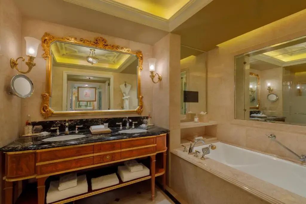 Luxuriöses Badezimmer mit großer Badewanne und antikem Spiegel