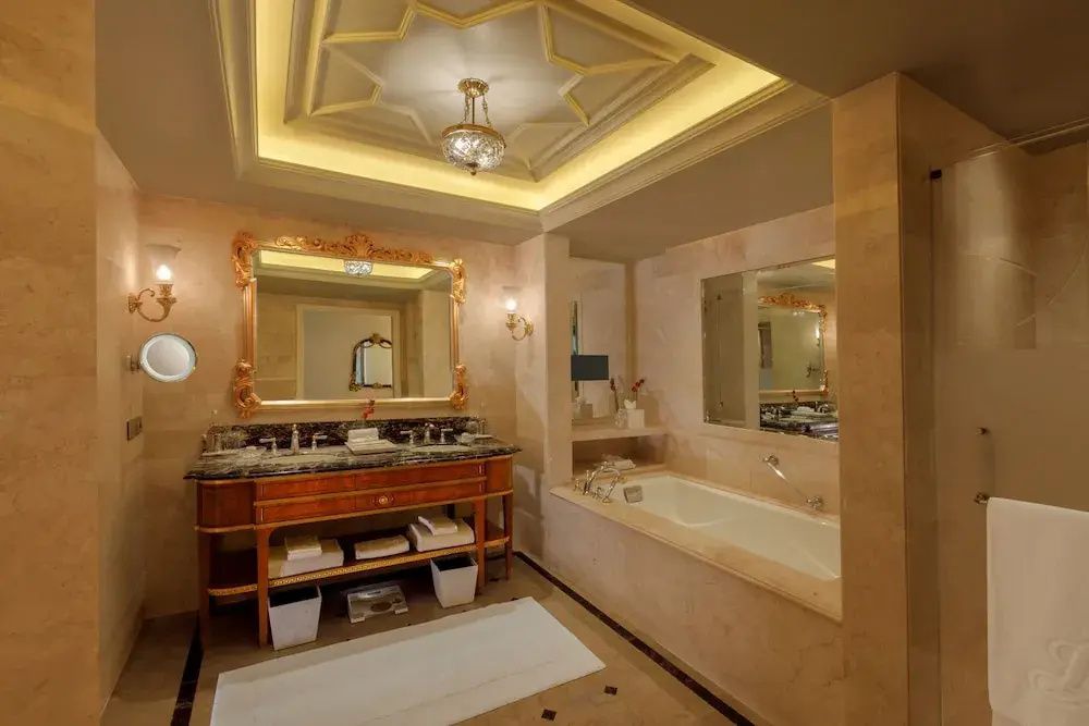 Luxuriöses Badezimmer der Royal Doppel Suite mit Marmor und klassischen Armaturen