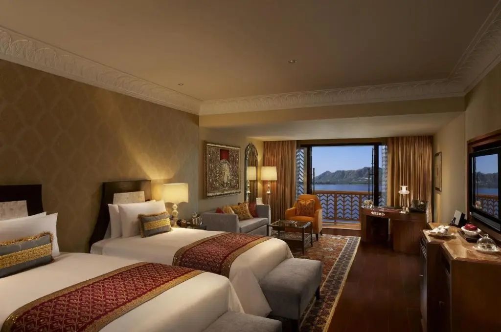 Zimmer mit zwei Betten und Panoramafenster mit Blick im The Leela Palace Udaipur