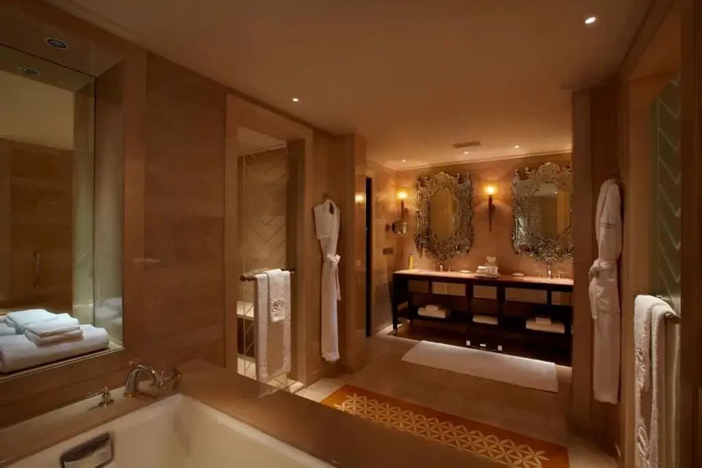 Opulentes Badezimmer in Naturtönen mit stilvollen Spiegeln und exklusiven Armaturen