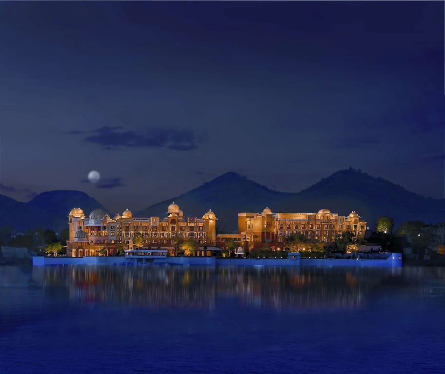 Hotelansicht des The Leela Palace Udaipur bei Nacht mit stimmungsvoller Beleuchtung