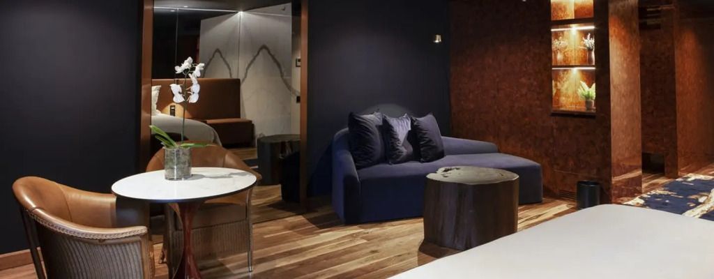 Stylisches Wohnzimmer einer Suite im Forte de Gaia Hotel mit blauer Couch und Holzboden