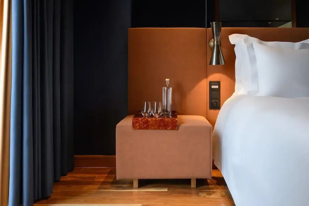 Nachttisch mit moderner Lampe und luxuriösen Details neben Doppelbett