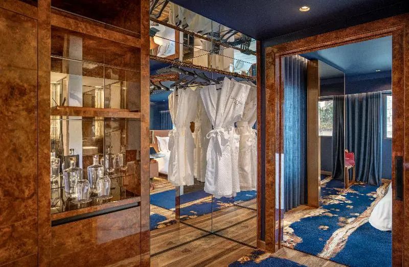 Garderobenbereich mit Bademänteln und Spiegeln in luxuriösem Hotelzimmer