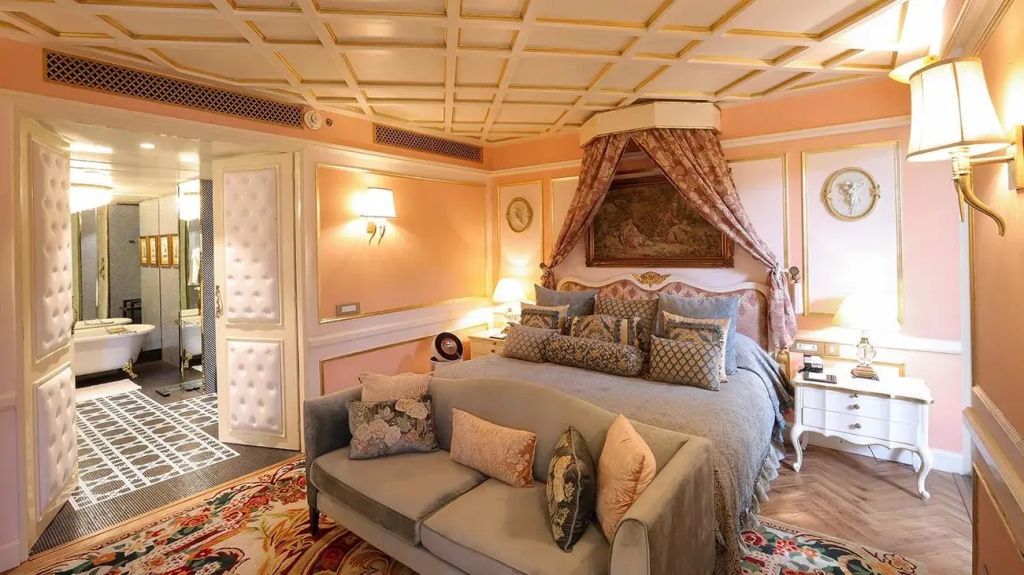 Luxuriöses Schlafzimmer mit gepolstertem Doppelbett und eleganten Vorhängen