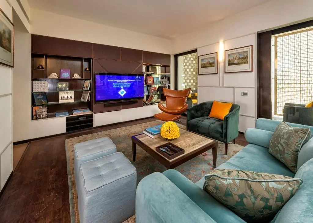 Geräumiges Wohnzimmer der Lodhi Suite mit modernen Möbeln und Unterhaltungssystem.