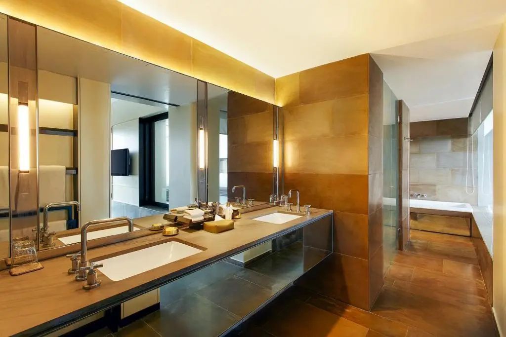 Modernes Badezimmer mit Doppelwaschbecken und großem Spiegel im Lodhi Hotel
