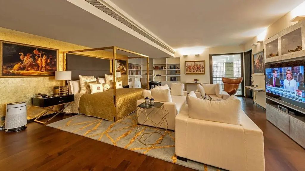 Elegantes Schlafzimmer mit Himmelbett, Sitzbereich und modernen Dekorationen