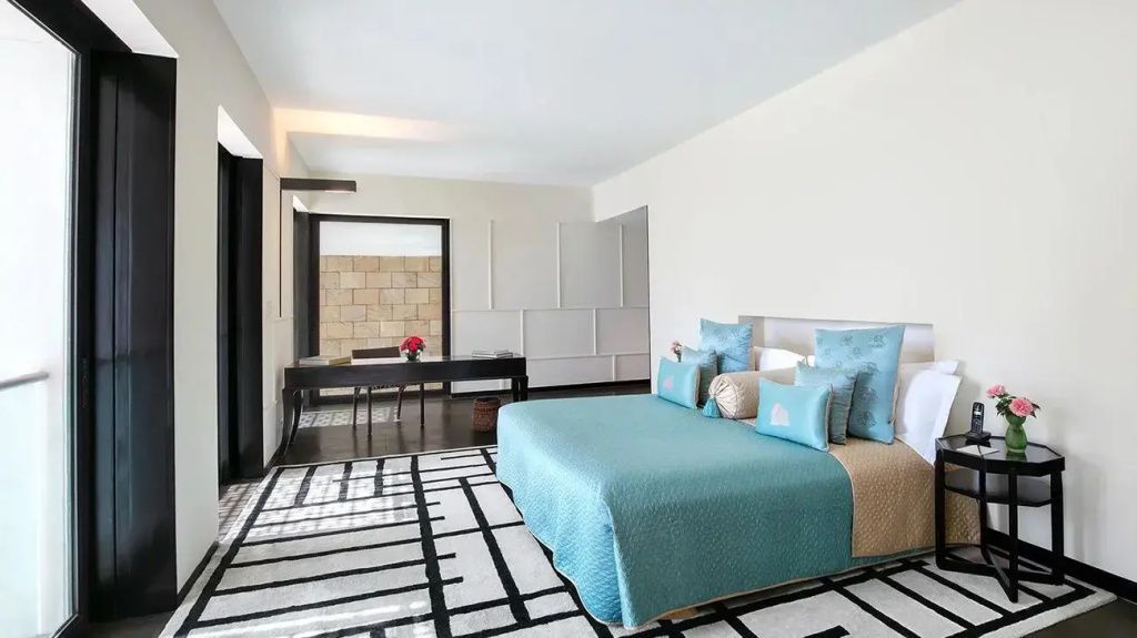 Geräumiges Schlafzimmer mit Doppelbett in der Verandah Pool Suite mit modernem Design
