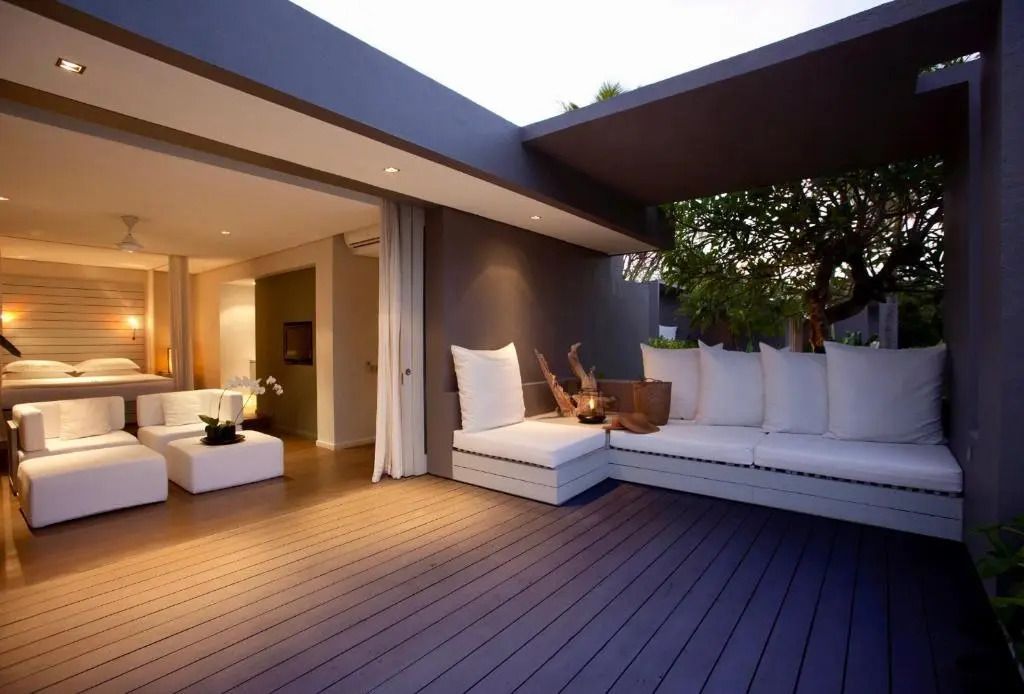 Eleganter Lounge-Bereich auf Terrasse mit weißen Sofas und Holzboden