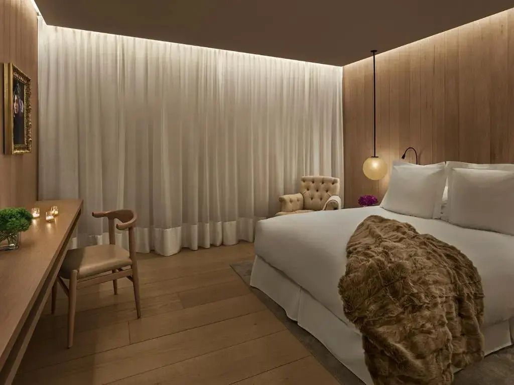 Stilvolles Hotelzimmer mit weichen Beige-Tönen und dezenter Beleuchtung.