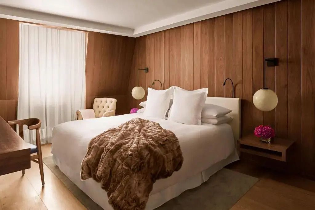 Helles Schlafzimmer mit Holzakzentwand und luxuriösem Doppelbett
