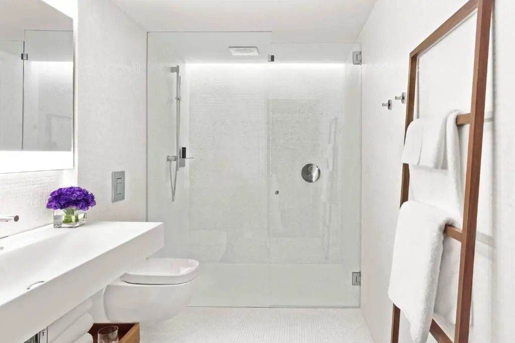 Minimalistisches Badezimmer mit Glasdusche und weißen Fliesen
