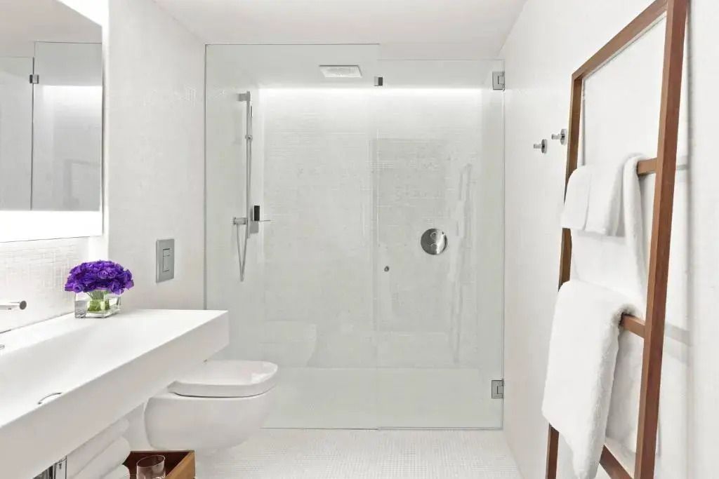 Modernes Badezimmer mit großer Glasdusche und weißen Wänden
