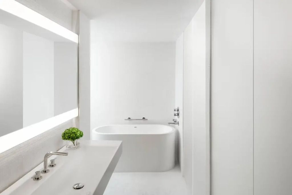 Modernes minimalistisches Badezimmer mit eleganter Badewanne im London EDITION Hotel.