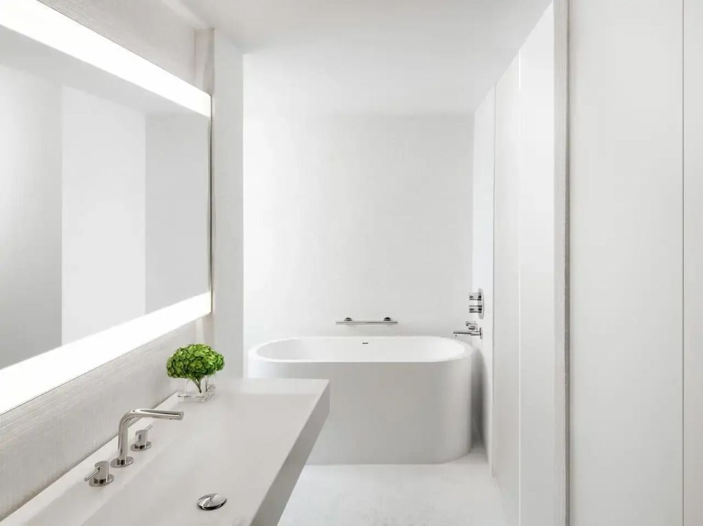 Modernes Badezimmer mit freistehender Badewanne, großer Spiegel und elegantem Waschbecken