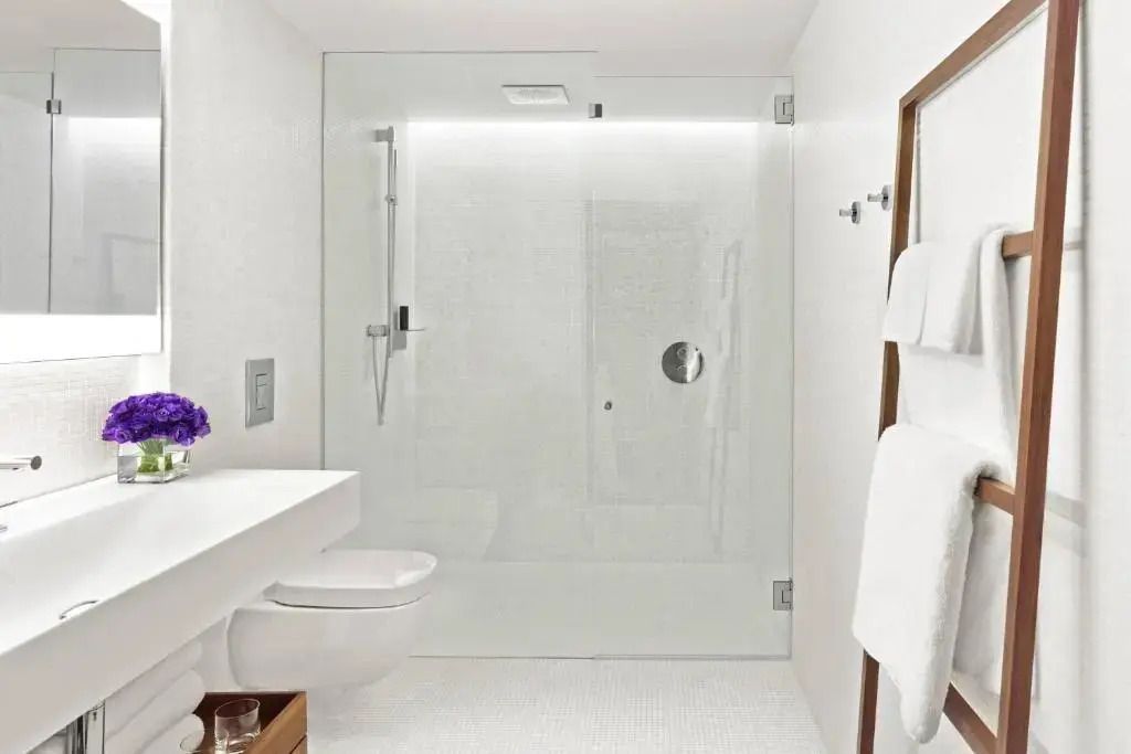 Modernes, minimalistisches Badezimmer mit großer Dusche und dezenten Dekorationen