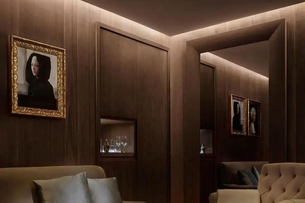 Luxuriöse Lounge mit dezenter Beleuchtung, Sofas und geschmackvollen Kunstwerken an den Wänden