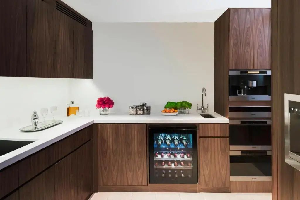 Moderne Küchenzeile der Penthouse Suite mit Holzelementen und Weinkühlschrank