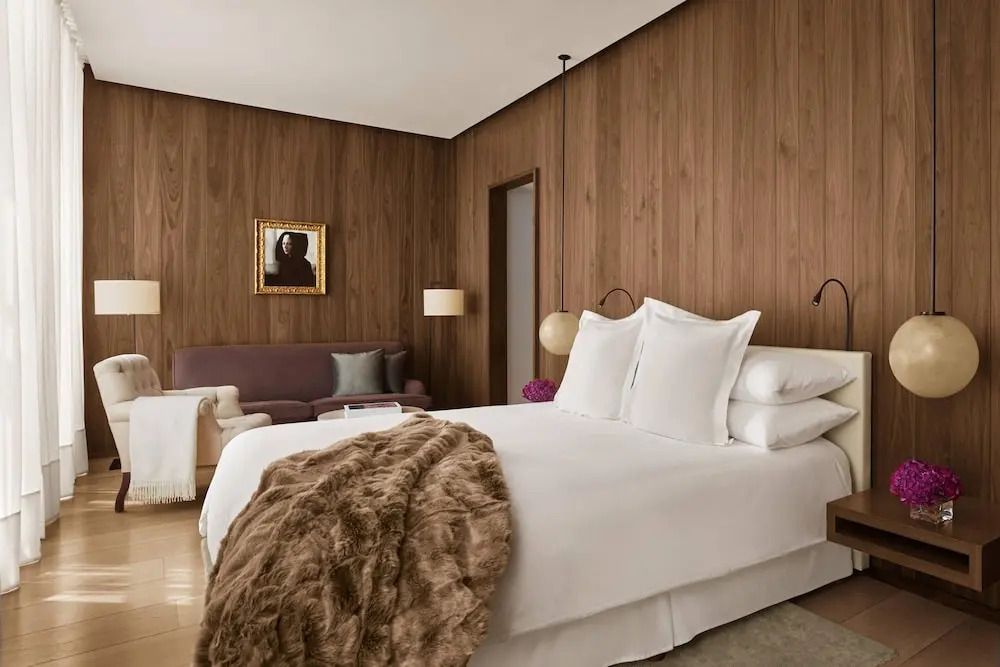 Gemütliches Doppelzimmer mit Holzwänden, großem Bett und stilvollen Details