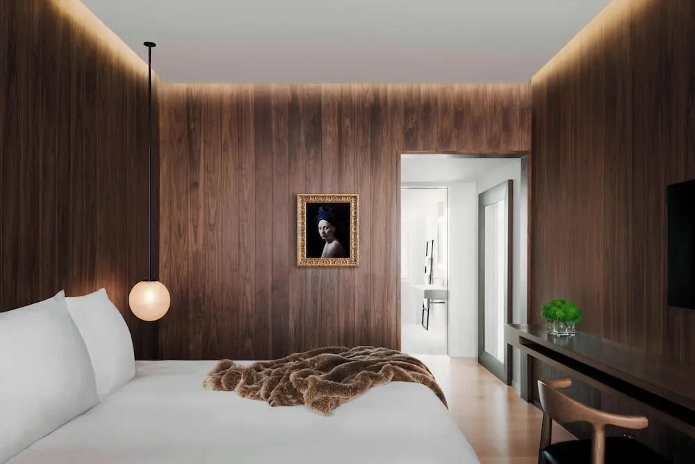 Schlafzimmer mit minimalistischer Einrichtung, Kunst an der Wand und weichem Teppich