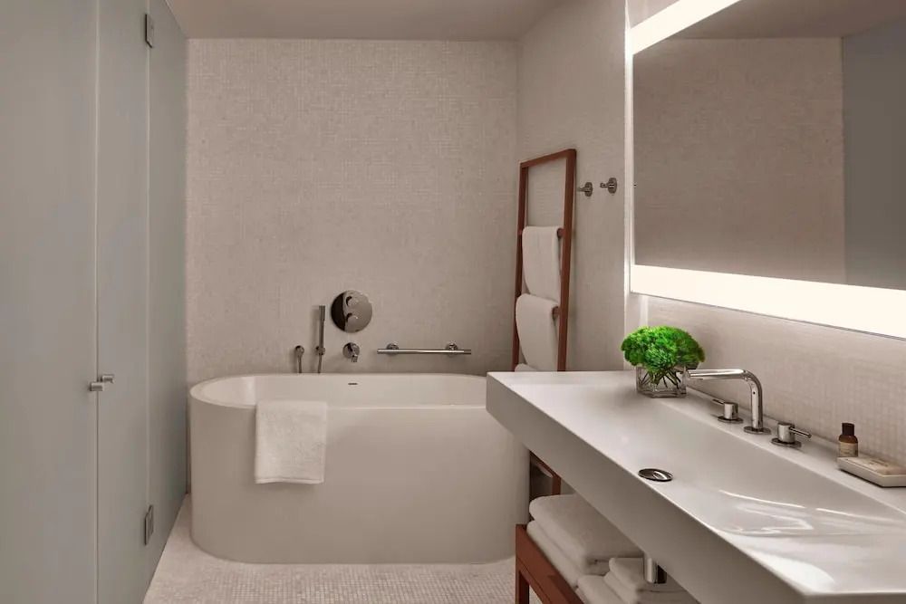 Modernes Badezimmer mit freistehender Badewanne und großem Spiegel