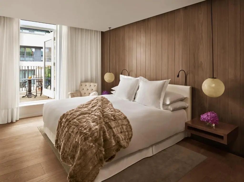 Elegantes Doppelzimmer mit Zugang zur Terrasse, stilvolles Interieur und Holzvertäfelung