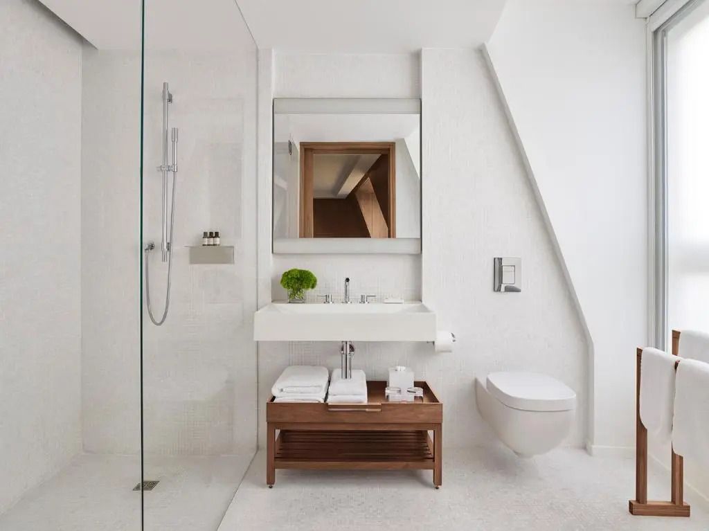 Luxuriöses helles Badezimmer mit stilvollem Waschbereich und großer Dusche
