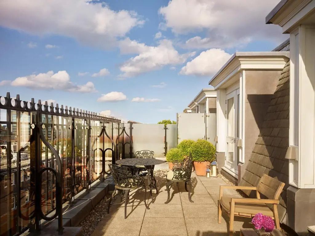 Geräumige Terrasse mit Sitzgelegenheiten und schöner Aussicht auf den Himmel