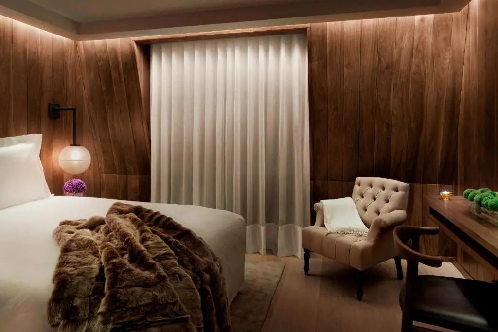 Modernes Hotelzimmer mit elegantem Sessel und weichem Bett.