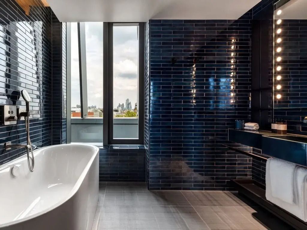 Modernes Badezimmer mit freistehender Badewanne und blauen Kacheln