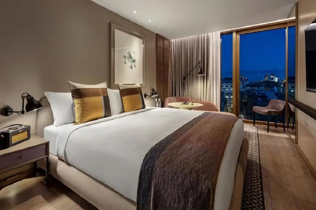 Modernes Hotelzimmer mit Doppelbett und Stadtblick bei Nacht