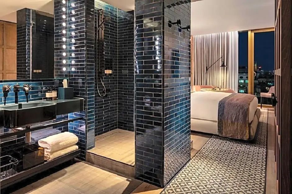 Offenes Badezimmer mit stilvoller schwarzer Fliesenwand im Hotelzimmer