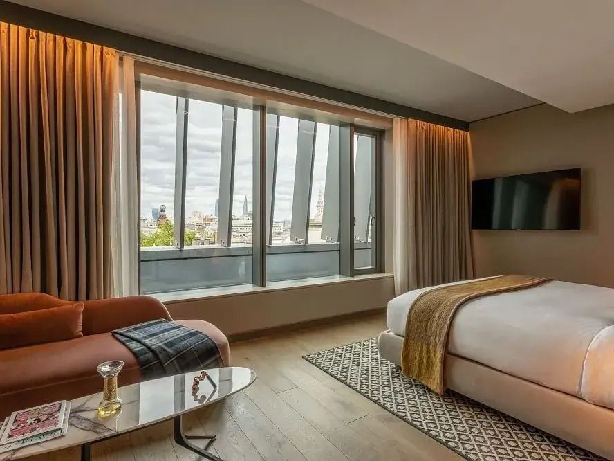 Junior-Suite mit Blick auf die Stadt, großem Fenster und stilvollem Interieur.