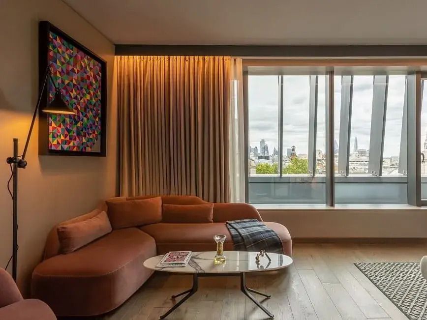 Moderne Sofaecke im Zimmer mit Panoramafenster und eleganter Kunst an der Wand.