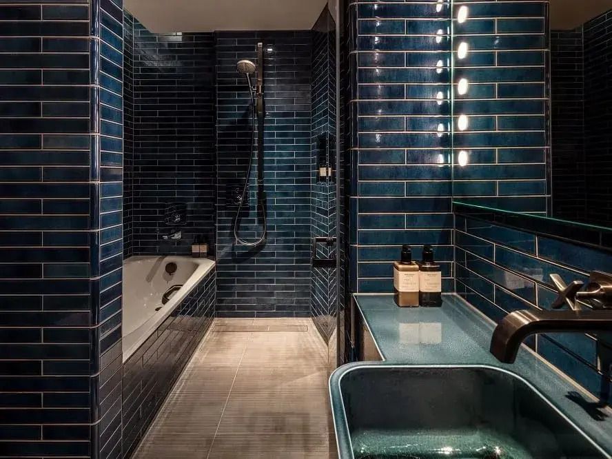 Luxuriöses Badezimmer mit blauen Fliesen und moderner Ausstattung.