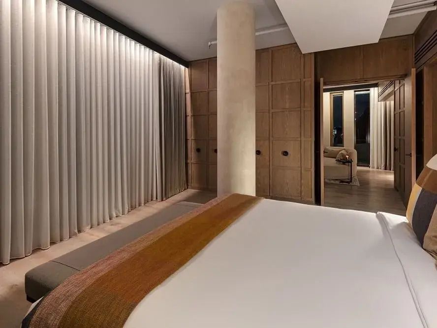 Schlafzimmer mit Vorhängen und Spiegelwandansicht in der Tower Penthouse Suite