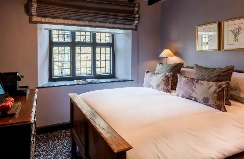 Helles Schlafzimmer mit Doppelbett und großen Fenstern
