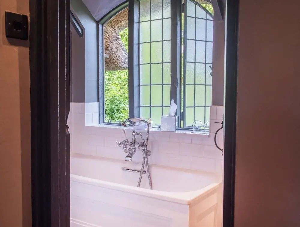 Elegantes Bad mit freistehender Wanne und großen Fenstern