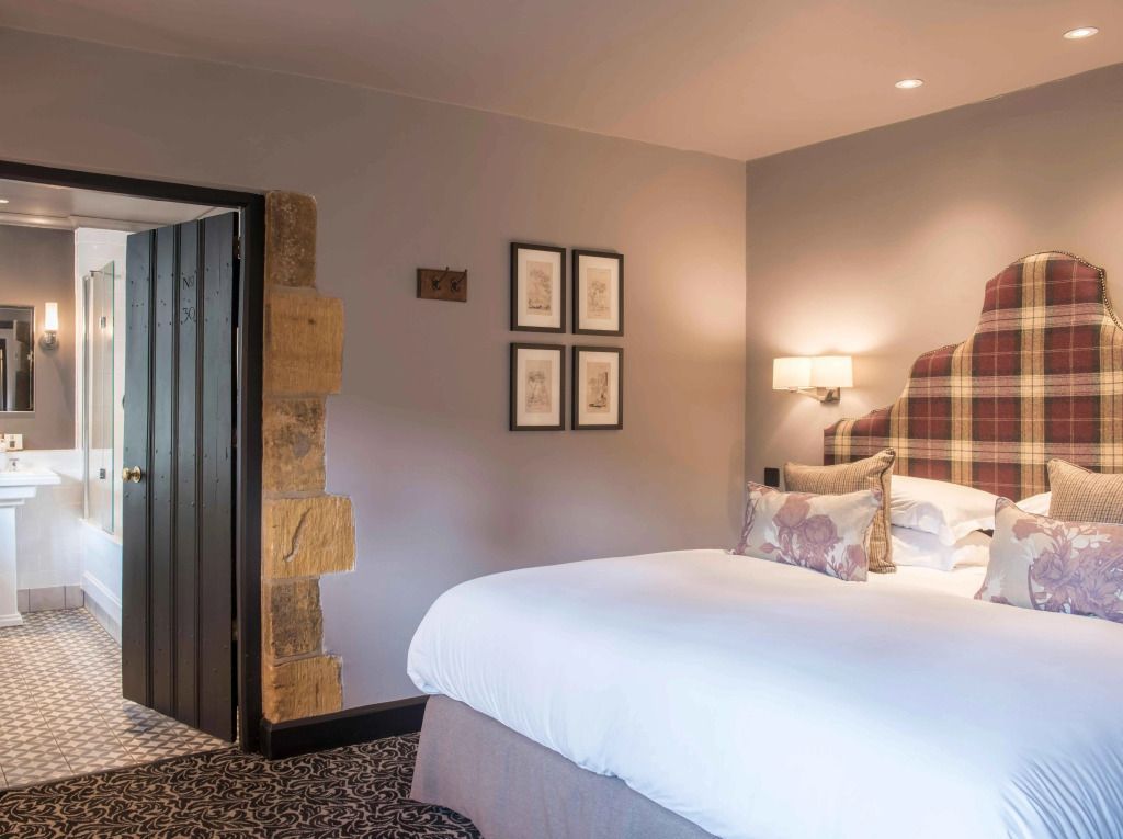 Elegantes klassisches Hotelzimmer mit gemütlichem Doppelbett und Wandkunst.