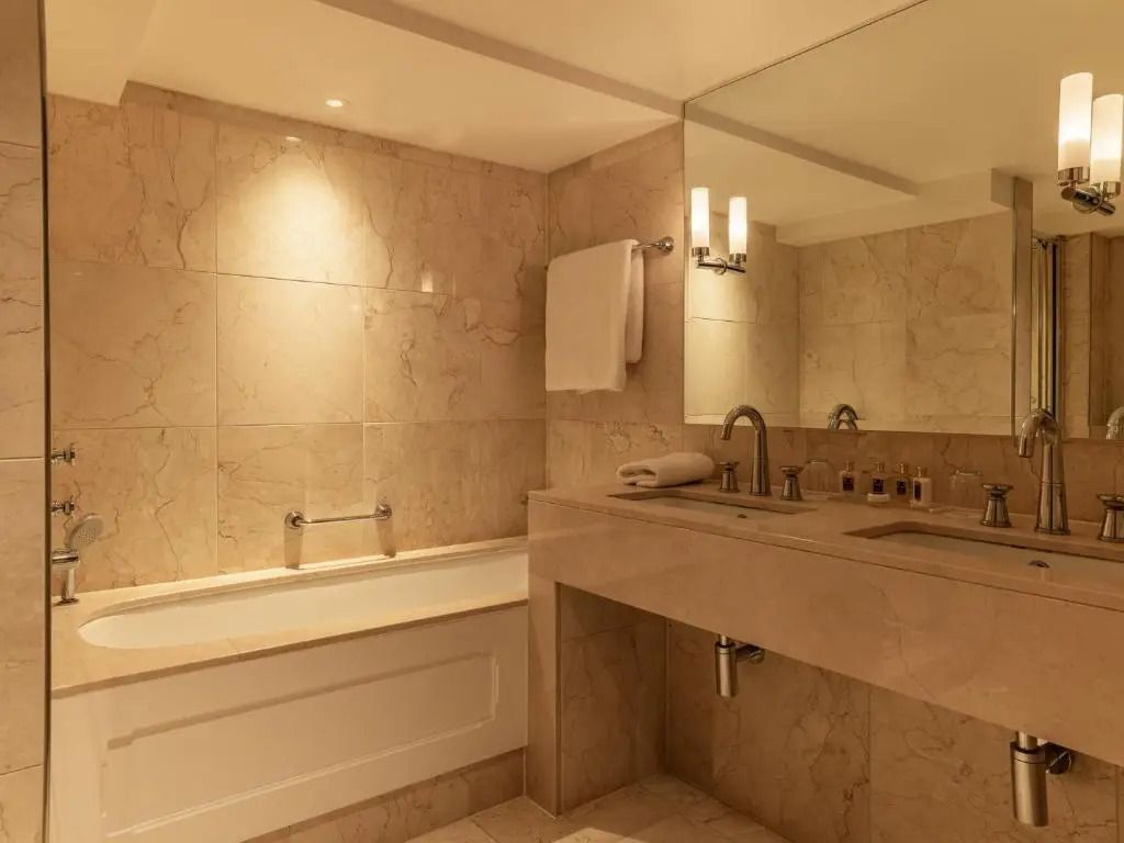Luxuriöses Badezimmer mit großen Spiegeln und warmen Lichtakzenten.