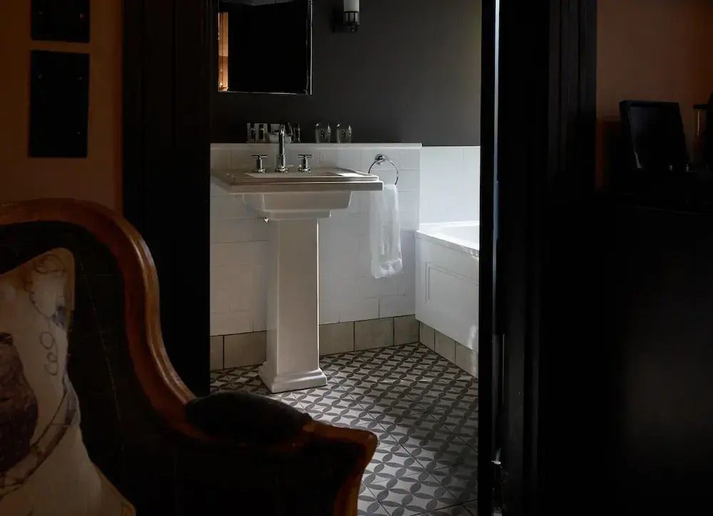 Badezimmer mit Waschbecken und Badewanne, Fliesendesign am Boden.