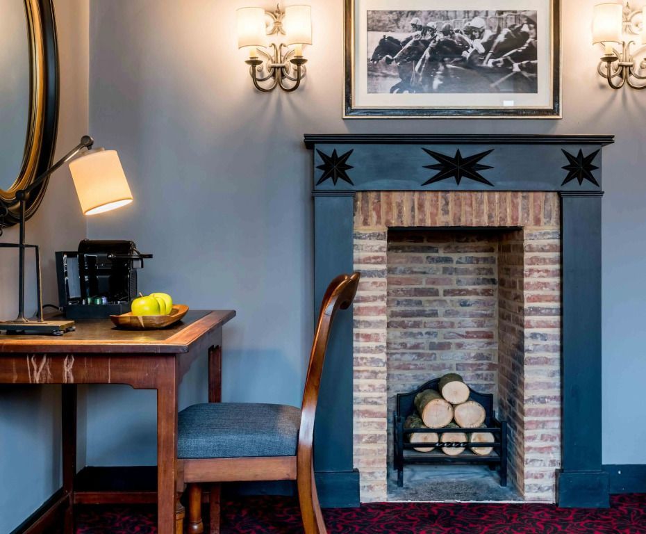 Gemütlicher Kamin in einer eleganten Suite mit Schreibtisch