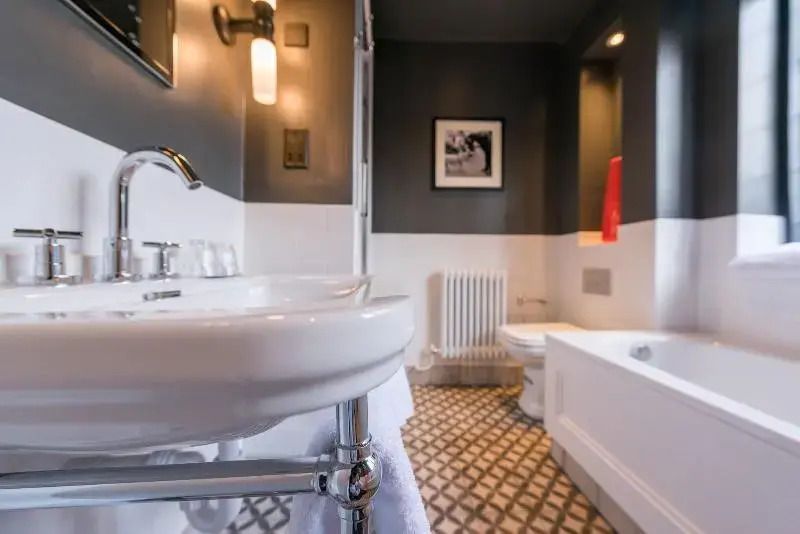 Elegantes Badezimmer mit modernen Armaturen und einer Badewanne im The Lygon Arms.
